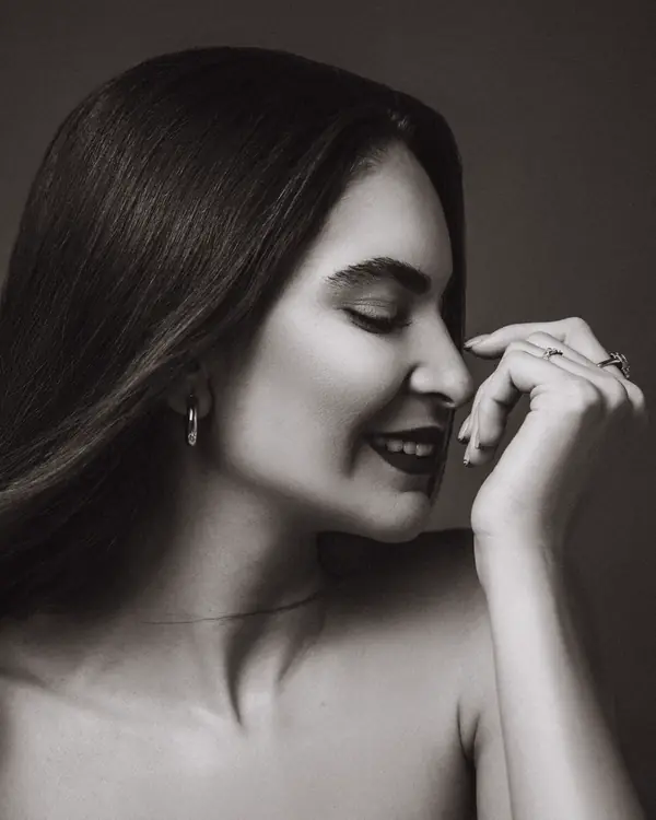 A woman in profile smiling softly, in black and white