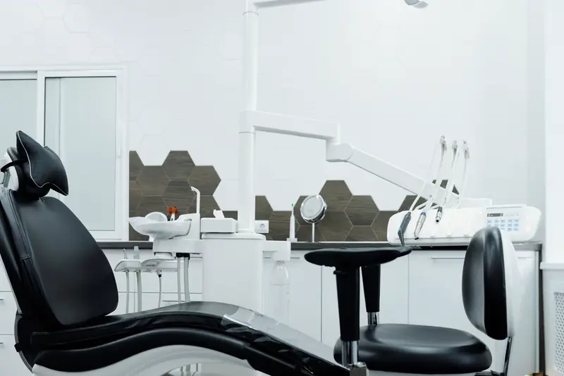 A private treatment suite with a black leather dental chair
