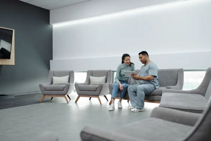 A dentist talks with a patient in a bright, quiet lounge