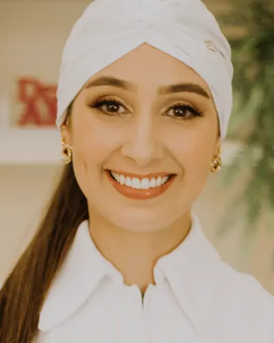 Maya Haddad smiling in a white uniform and head wrap