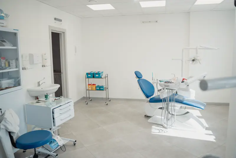 A clean treatment room with a blue dental chair