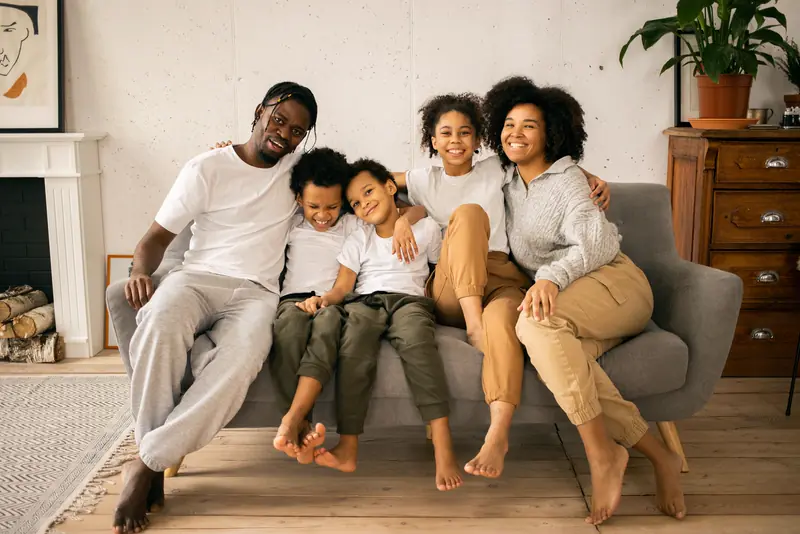 Family of five relaxing together on a living room sofa