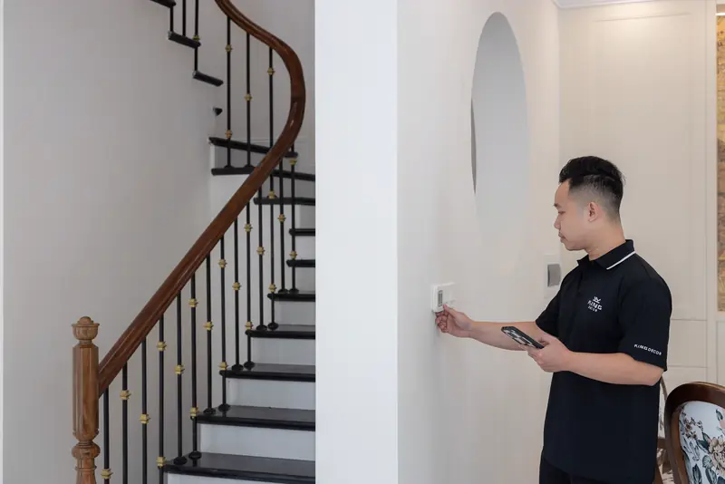 Technician setting up a smart thermostat in an entry hall