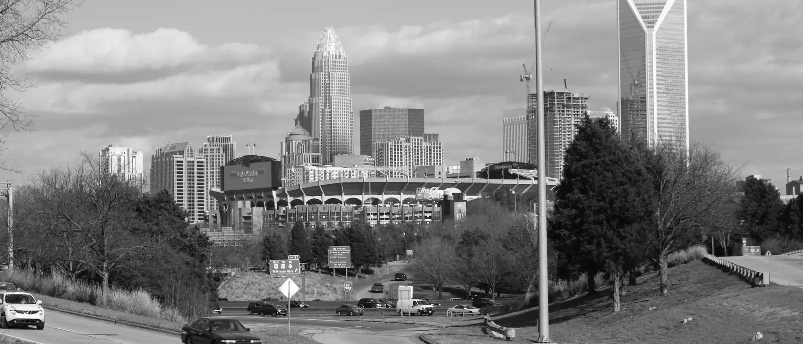 Black and white view of the Charlotte skyline from a hillside road