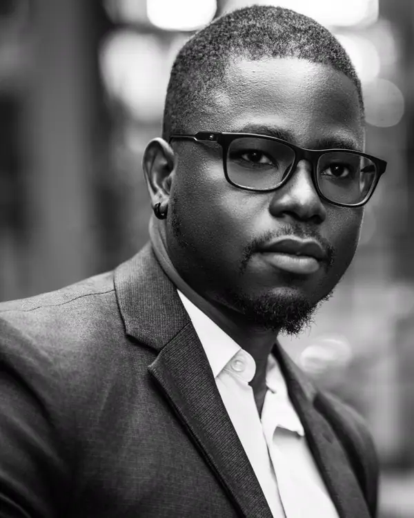 Jordan Okafor in glasses and a suit jacket