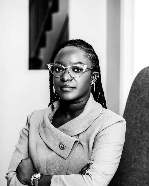 Naomi Reyes in glasses and a light jacket, arms crossed