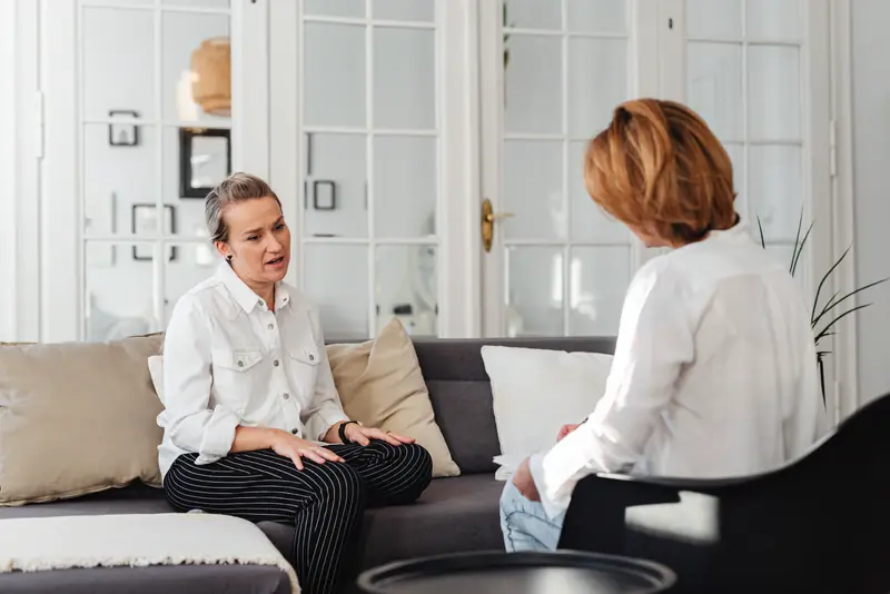 An attorney listens to a client in a bright, quiet meeting room