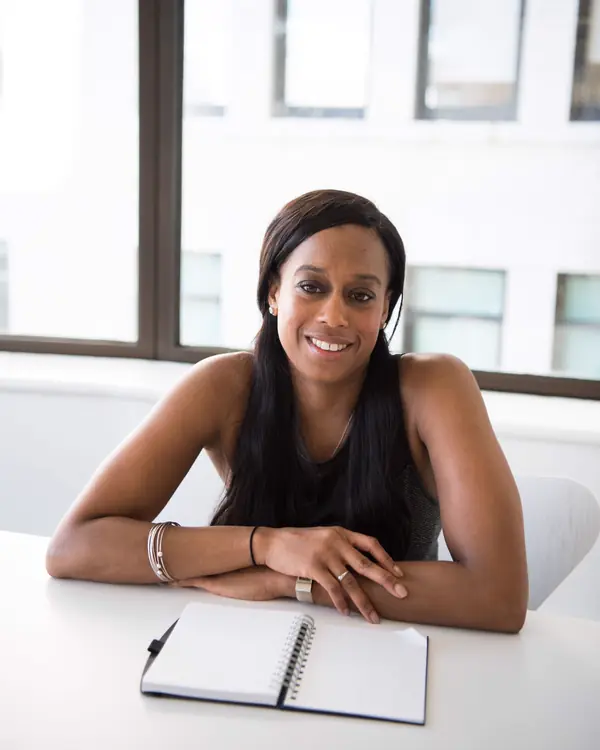 Simone Carter smiling at a desk in a bright office