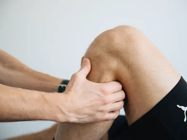 A therapist works on an athlete's knee.