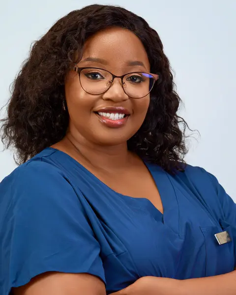 Portrait of Aisha Bello in blue scrubs.