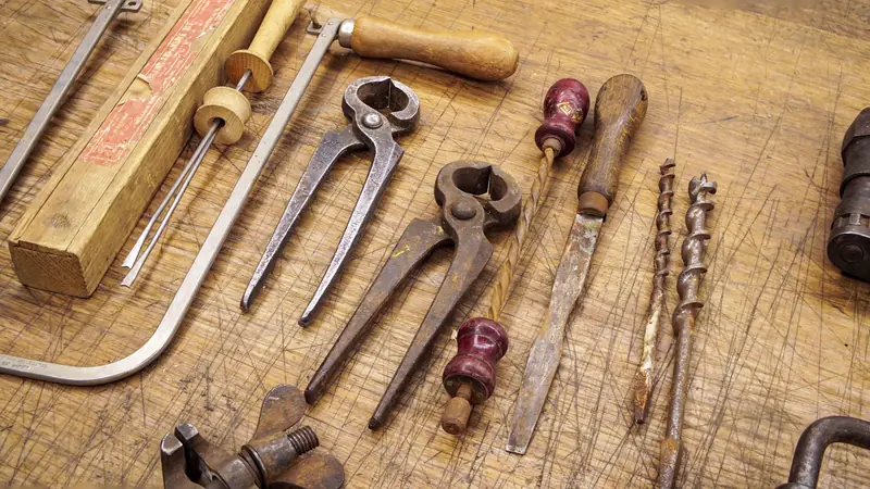 Old hand tools laid out on a wooden workbench