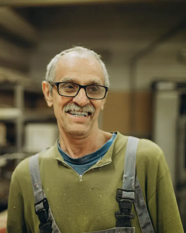 Portrait of Ray Hartley smiling in work overalls