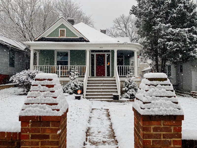 A bungalow with a snowy front walk
