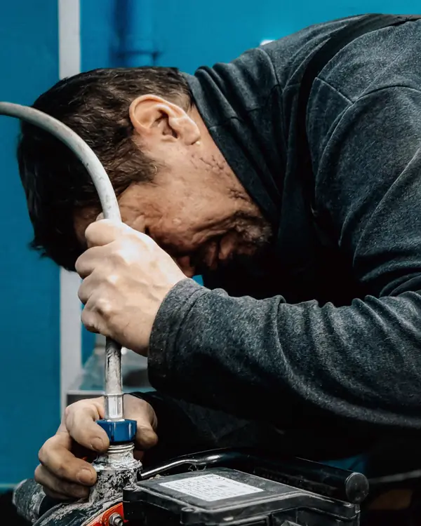 A Torrent plumber fitting a hose to a pump during a sewer job