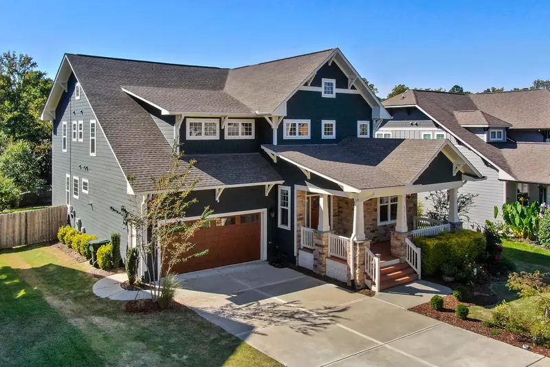 Gray two-story craftsman home with a covered front porch and a two-car garage