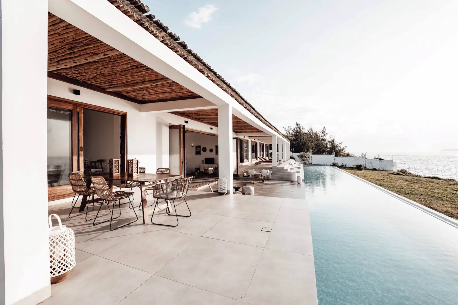 Covered terrace with a long infinity pool running toward the Gulf