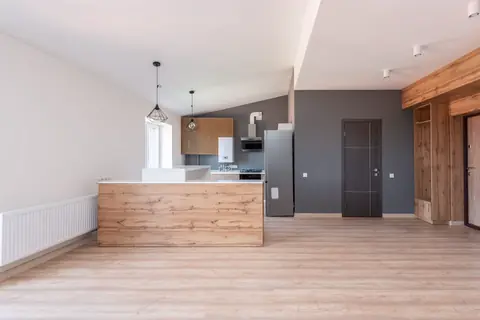 Open kitchen with a wood-front island and pendant light