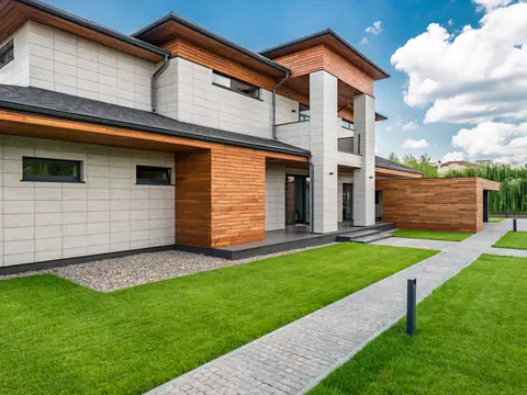 Modern two-story house with cedar and white panels and a long front walk