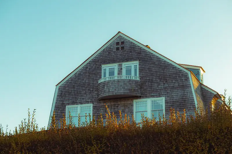 Shingle-style gambrel house sided and roofed in weathered cedar