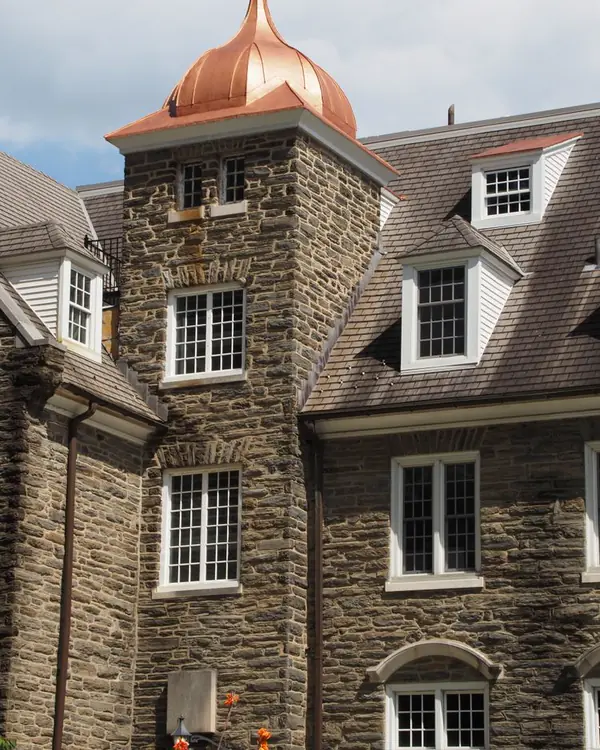 Stone college hall with a new copper dome on its tower