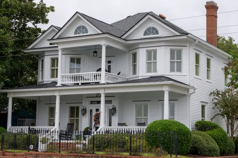 White house with a two-story porch and gray metal porch roofs
