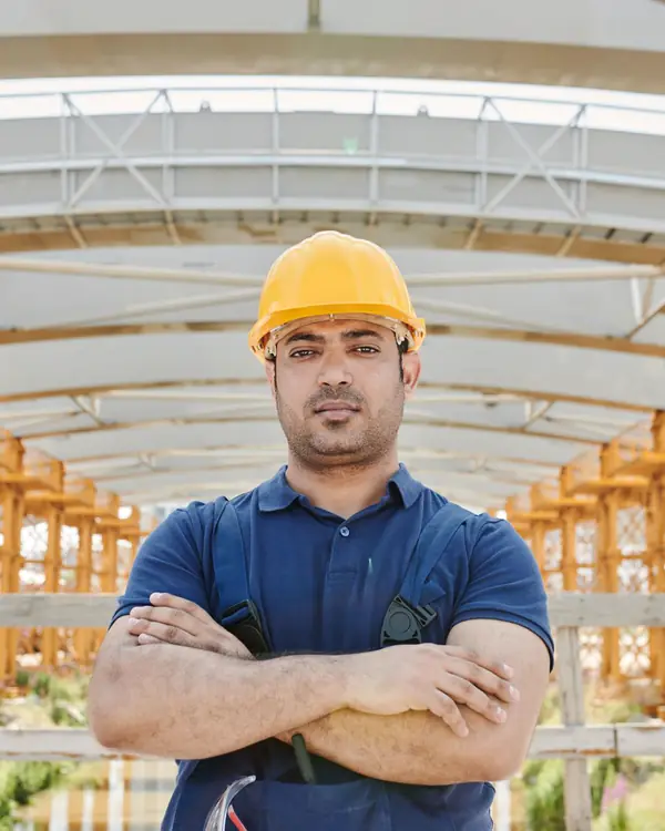 Dario Medina in a yellow hard hat with arms crossed
