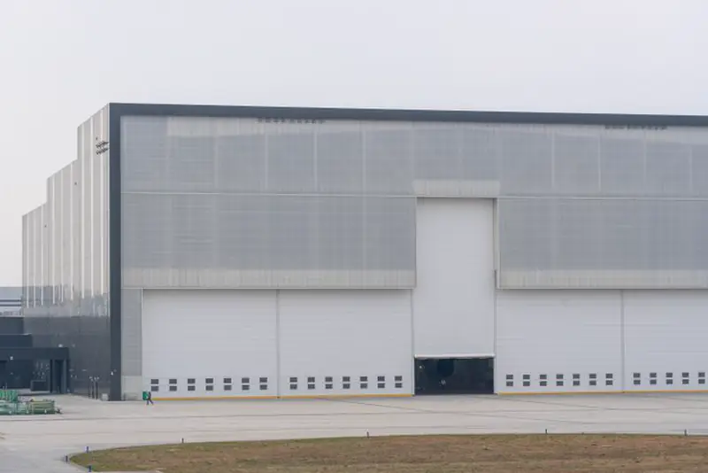 Large modern gray warehouse with tall closed loading doors