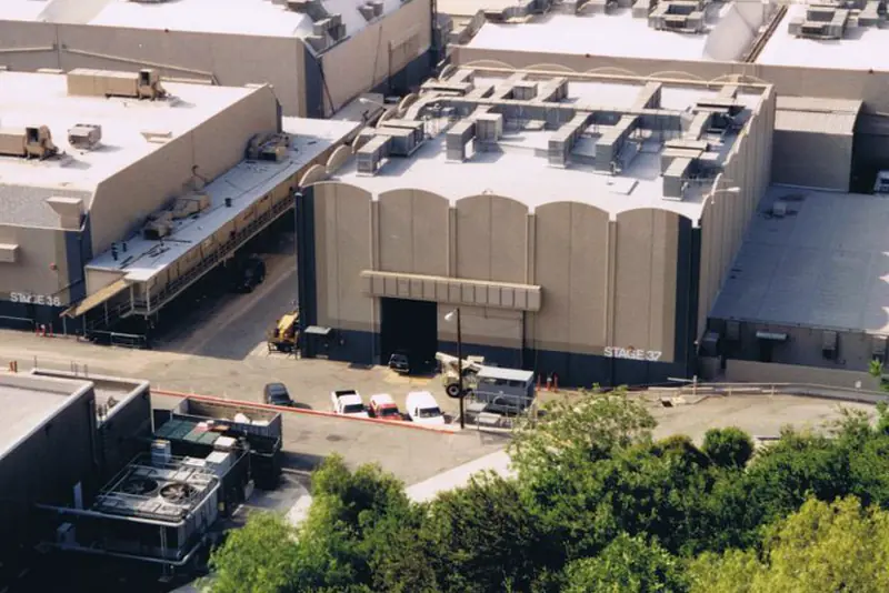 Aerial view of several large flat-roofed industrial buildings with white roofs