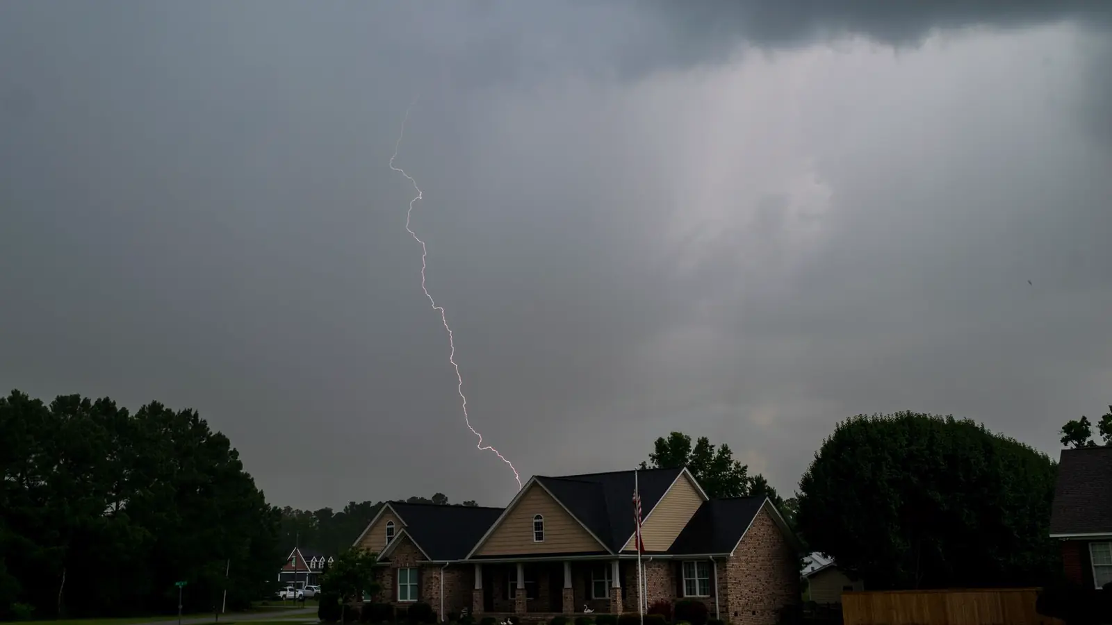 Lightning over a brick home in a Fort Worth neighborhood during a spring storm